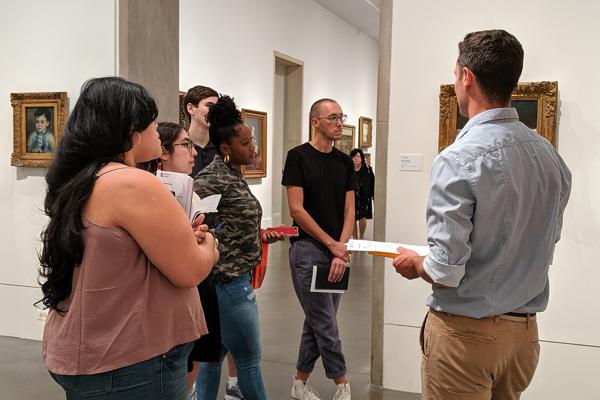 People stand around a museum gallery looking at art work
