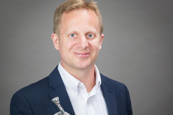 Jason Dovel headshot with trumpet in hand