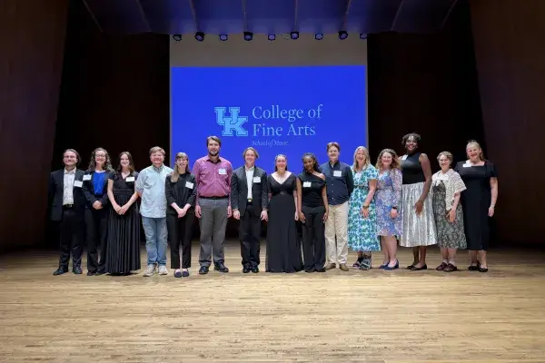 Fifteen School of Music students stand onstage at the Singletary Center as part of the awards ceremony