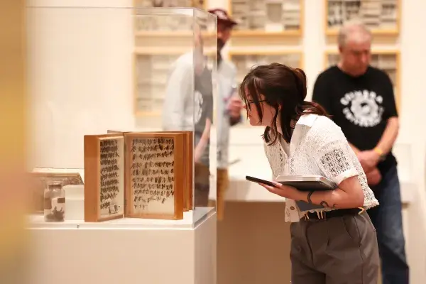 "Visitor examines museum artifact display case."