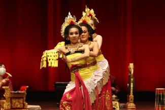 traditional dancers on stage in gold and red costumes