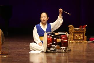person playing drum on floor on stage