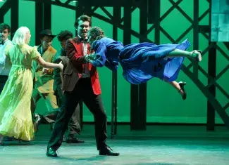 person swinging another person on stage in costume