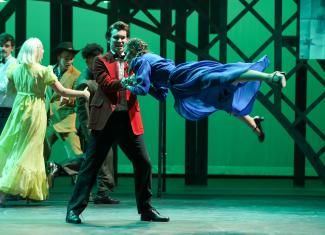 person swinging another person on stage in costume