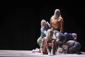 group of dancers on stage with bags on their heads