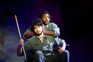 two people on stage with one holding the other's ears