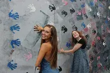 dancers smiling at mural in berlin