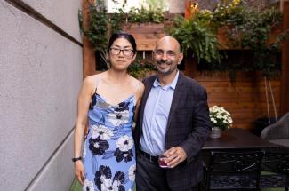 UK's Yuha Jung (left, wearing flowered sun dress) with Drexel University's Neville Vakharia (right, wearing grey suit and blue shirt), her coeditor, at the summer book launch party in Lexington. Photo by Mary Rollins Mathews, Rollins Studio.