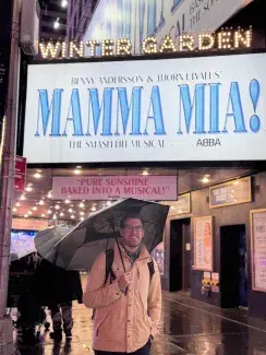 Ben Otten under an umbrella standing in front of Mamma Mia marquee