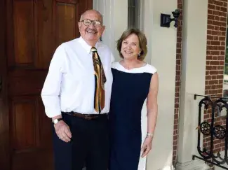 ben kaufmann and janet zusman smile at the camera and pose in front of a door
