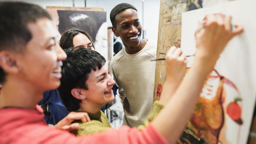people smiling looking at art canvas