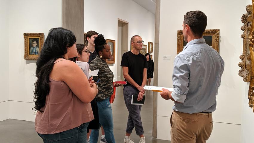 People stand around a museum gallery looking at art work