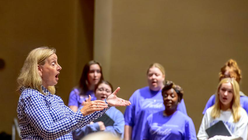 Lori Hetzel conducting student vocalists