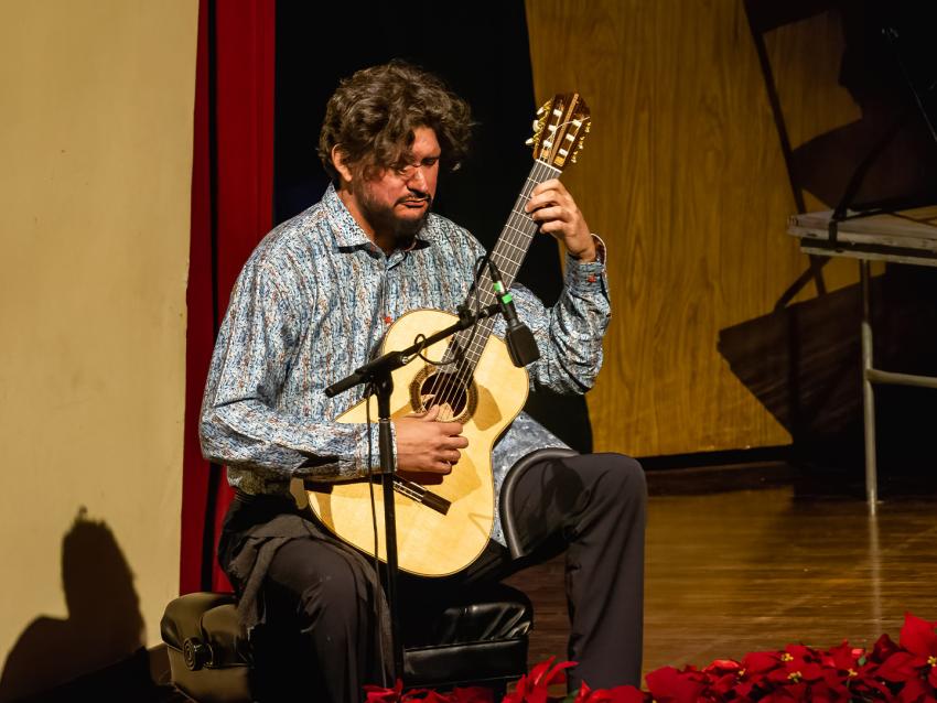 Image of Dieter Hennings Yeomans performing with guitar onstage at the Singletary Center during a performance of Collage in 2022.
