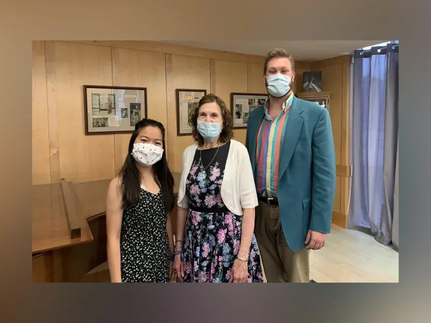 Image of three people wearing face masks posing inside a music studio