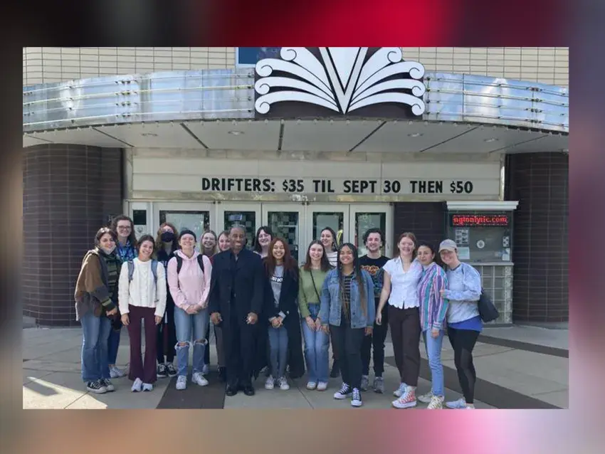 Image of students gathered outside in front of the Lyric Theatre's marquee, during the daytime