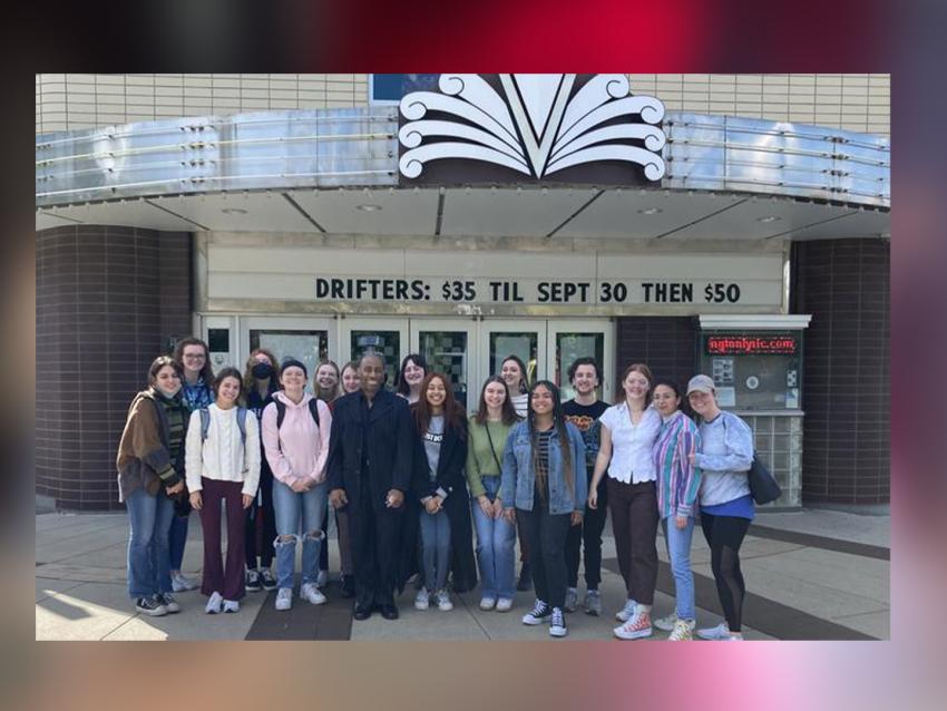 Image of students gathered outside in front of the Lyric Theatre's marquee, during the daytime