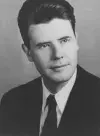 A black and white headshot of a younger Hubert Henderson in a suit and tie.