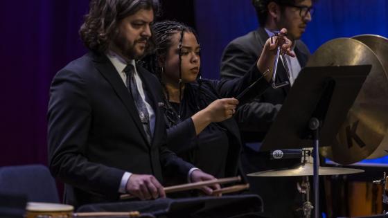 students playing percussion instruments on stage