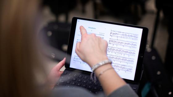 student pointing to music on ipad