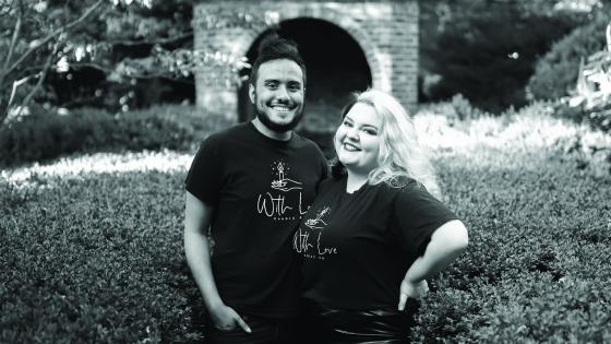 Tommy Townsend and Alexandra Burns post together wearing tshirts with the With Love business logo, black and white photo