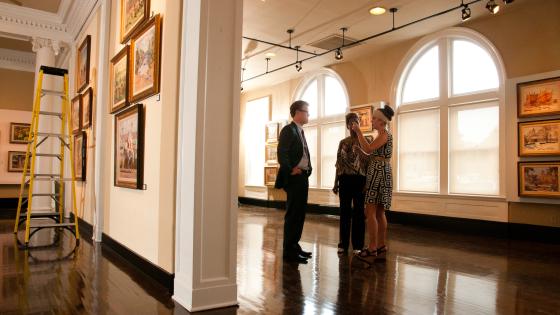 three people talking in a gallery
