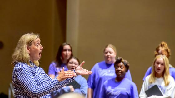 Lori Hetzel conducting student vocalists