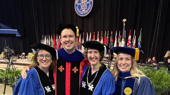 people in doctoral robes at commencement ceremony