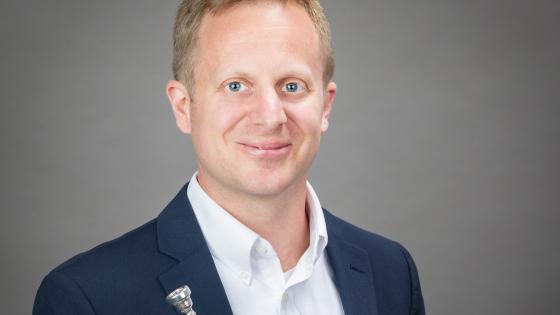 Jason Dovel headshot with trumpet in hand