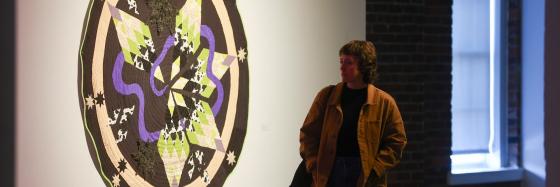 person walking by art on gallery wall