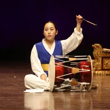 person playing drum on floor on stage