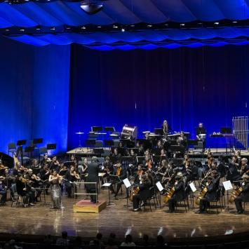 SYMPHONY ORCHESTRA ON STAGE IN BLUE LIGHTS