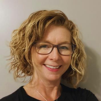 person looking at camera with glasses and chin length blonde hair