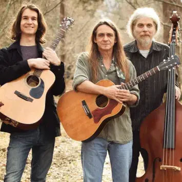 The band Zoey Speaks lined up with their instruments in an autumn forest. From left to right: Zoey Barrett, Arlo Barnette, Mitch Barrett, Owen Reynolds, and Carla Gover.