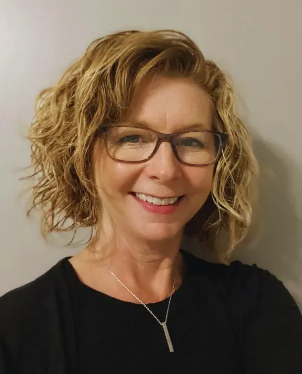 person looking at camera with glasses and chin length blonde hair